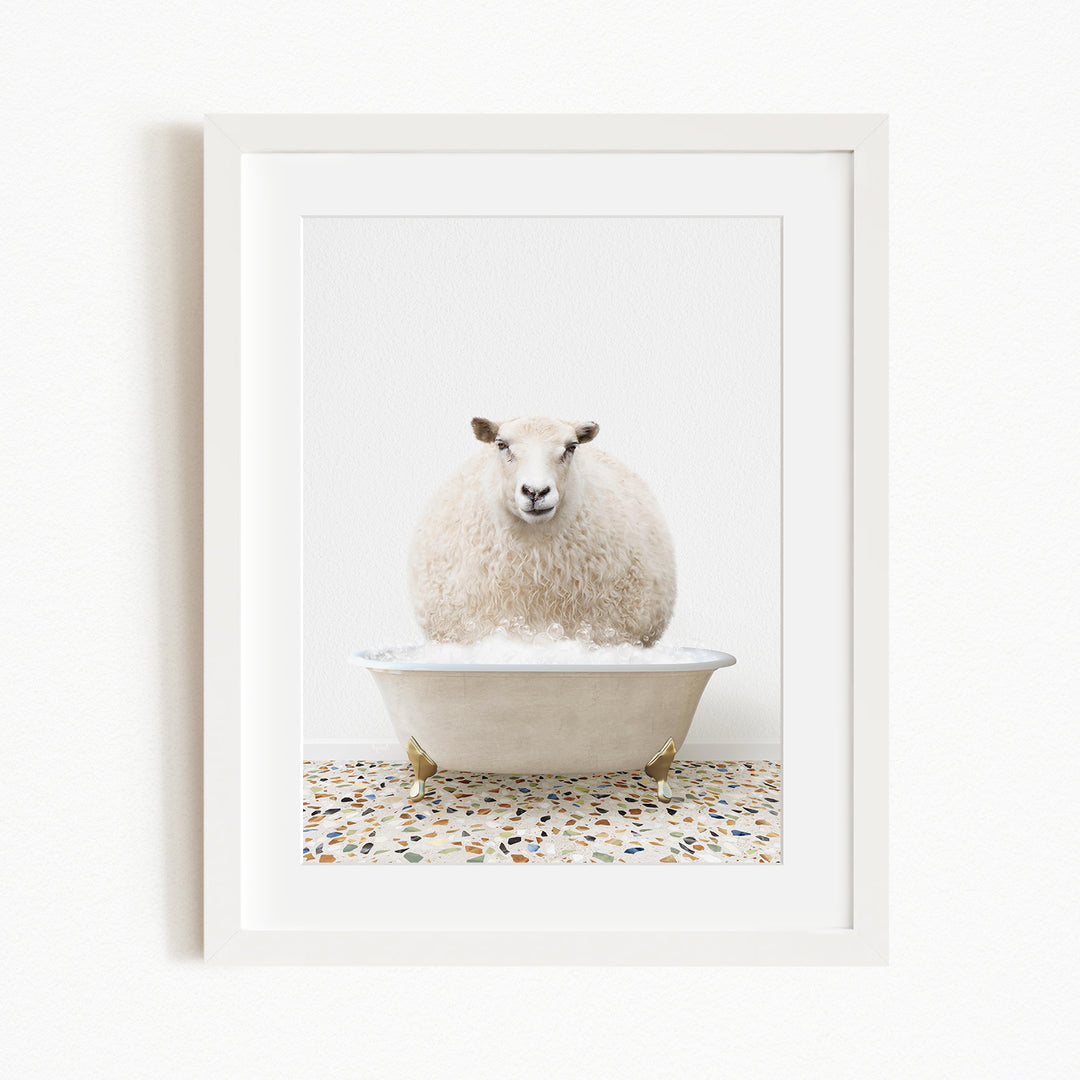 A fluffy white sheep sits in a white bathtub filled with bubbles, creating a whimsical and playful scene.