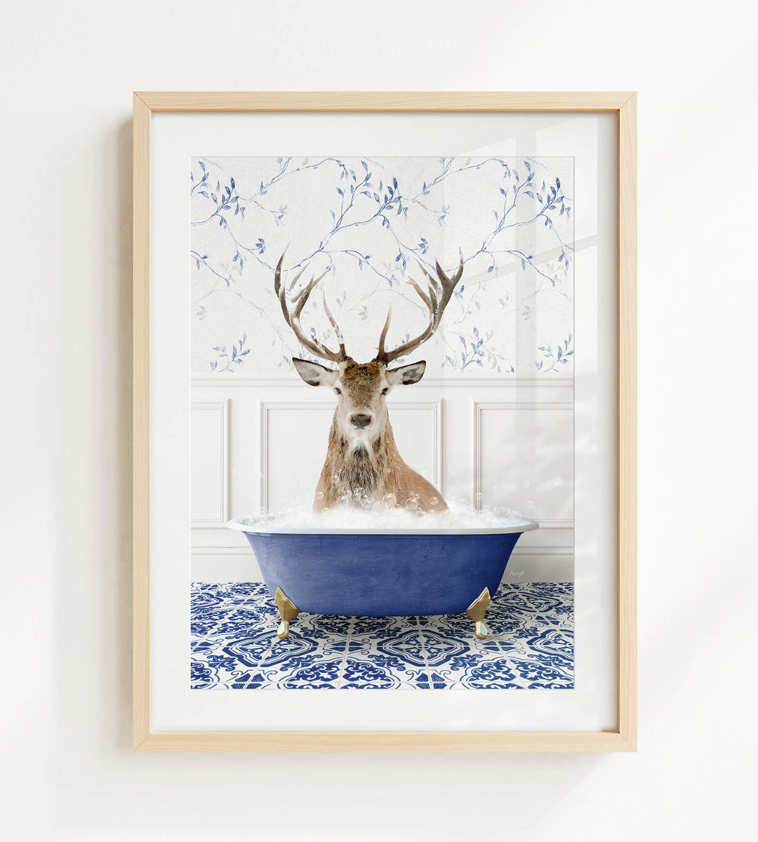 A deer with large antlers is sitting in a blue bathtub, surrounded by a patterned tile floor and a white wall with blue floral wallpaper.