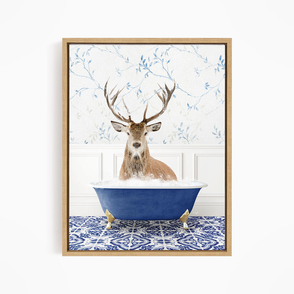 A deer with large antlers is sitting in a blue bathtub, surrounded by a patterned tile floor and a floral wallpaper background.