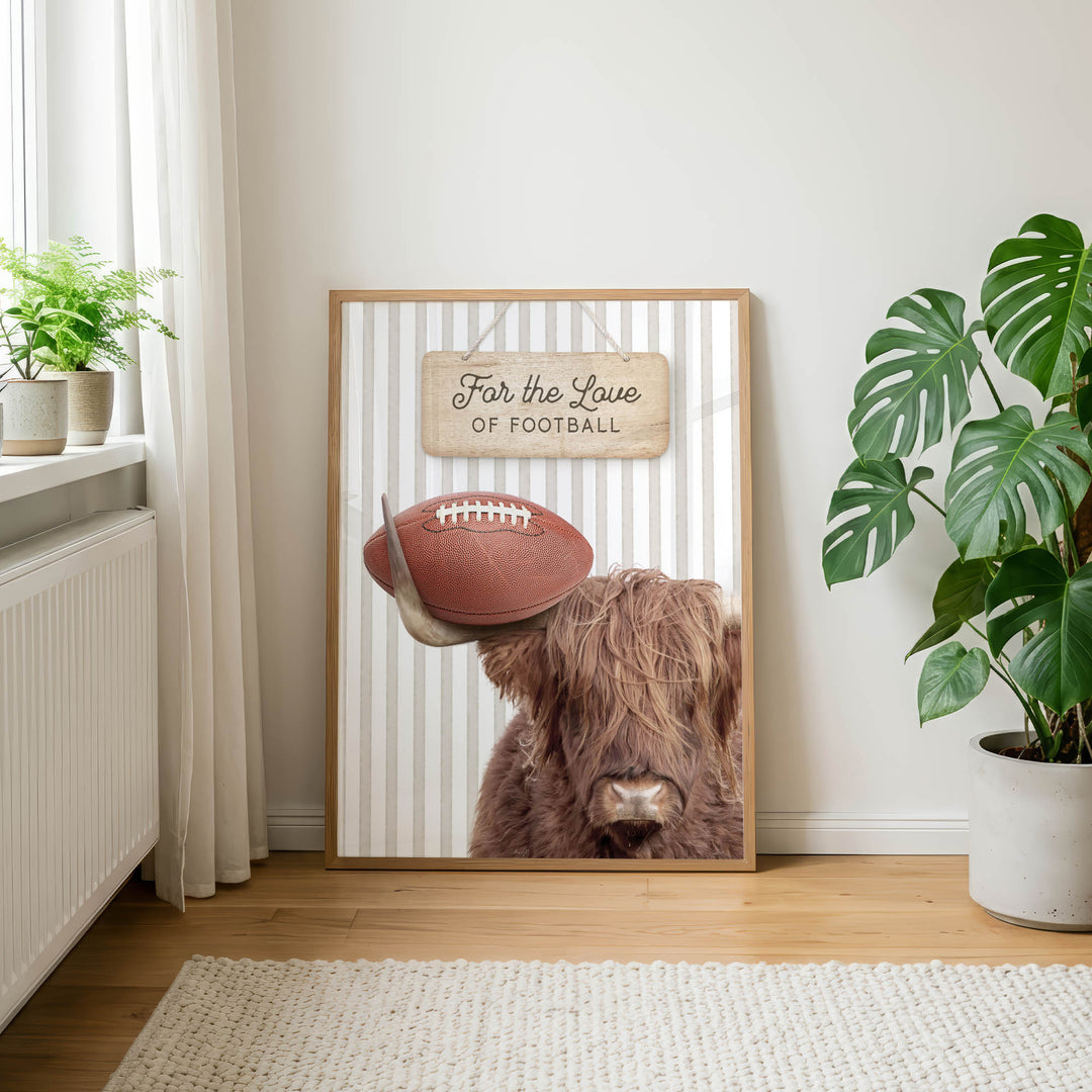 a framed poster with a picture of a Highland cow holding a football, accompanied by the text "For the Love of Football" on a striped background.