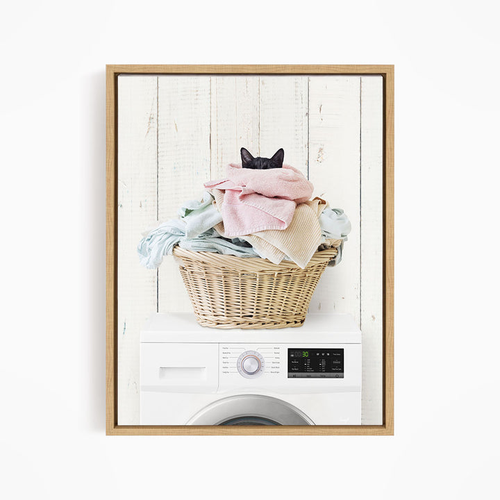 A cat is sitting on top of a basket filled with laundry, which is placed on top of a washing machine.