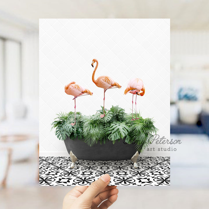 a person holding up a card with three flamingos in it