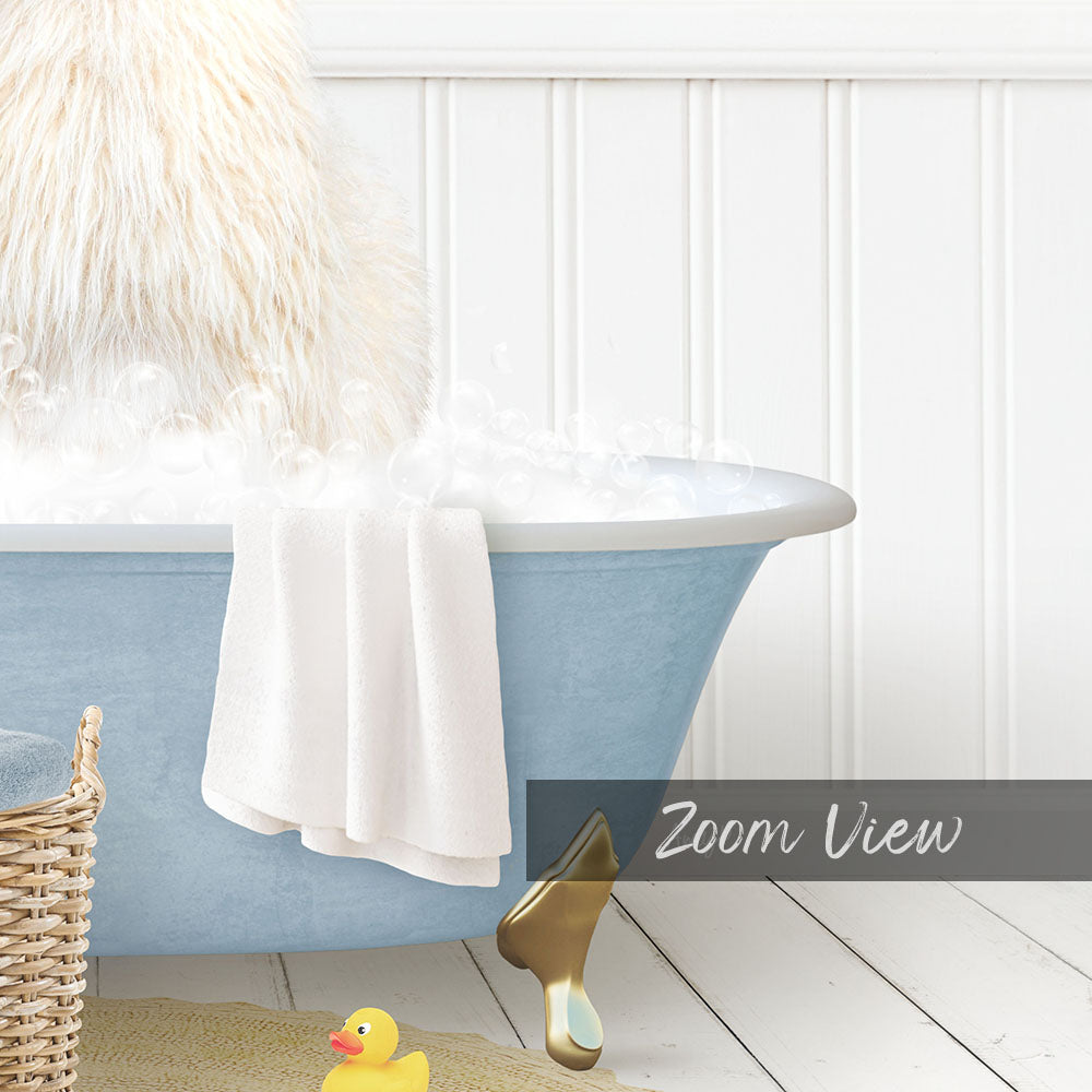 A fluffy white dog is sitting in a blue bathtub filled with bubbles, with a towel and a rubber duck nearby.