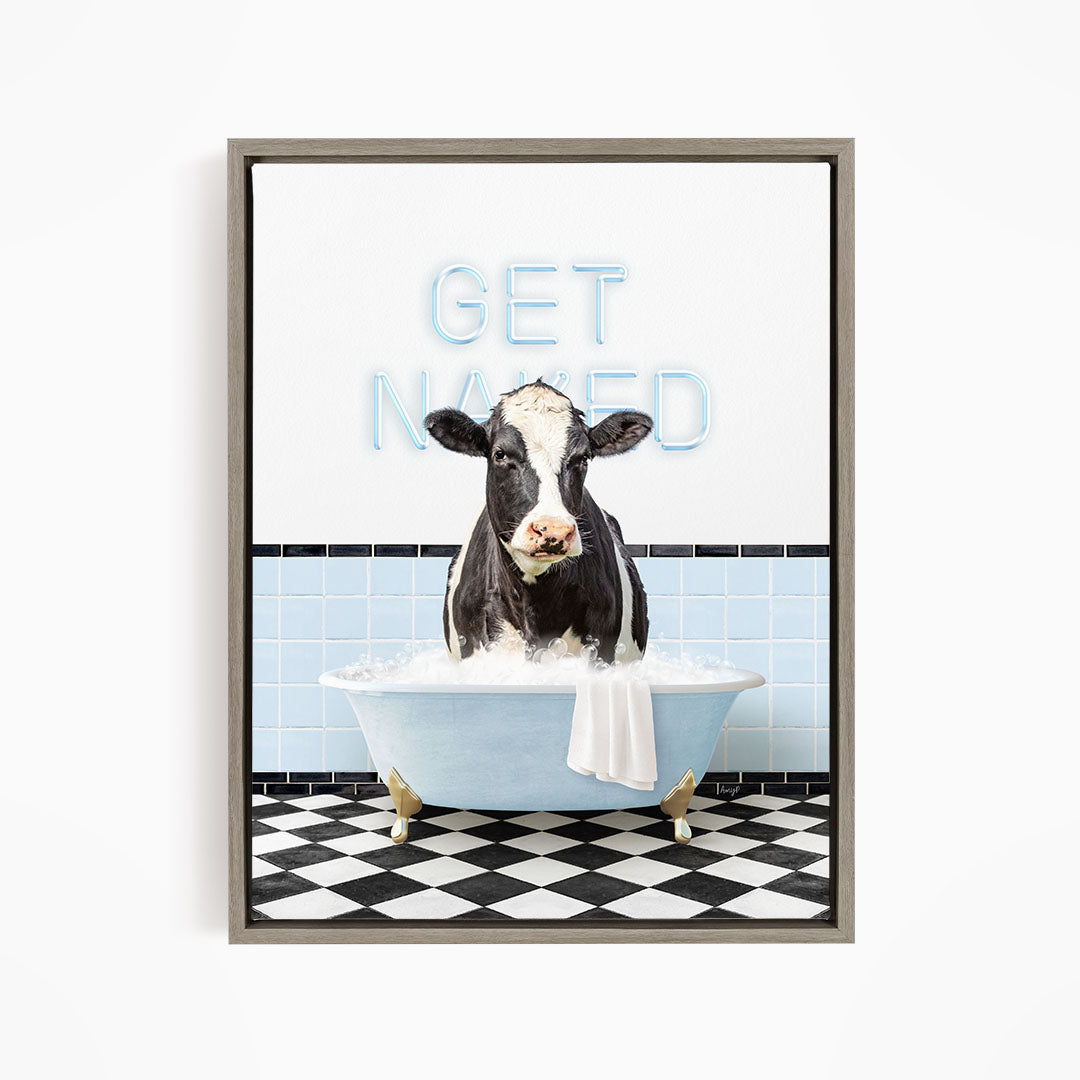 A black and white cow is sitting in a bathtub filled with water, with the words "GET NANED" written on the wall behind it.