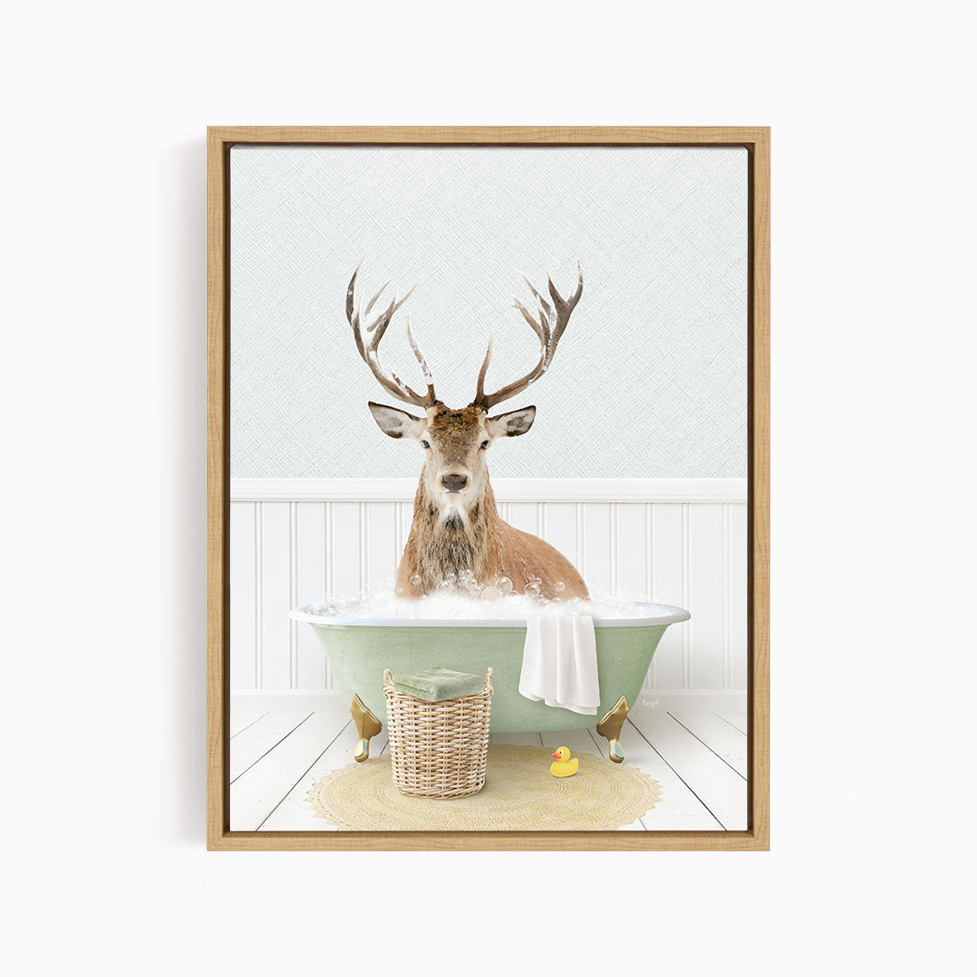 A deer with large antlers is sitting in a green bathtub filled with bubbles, surrounded by a basket of toys and a yellow rubber duck.