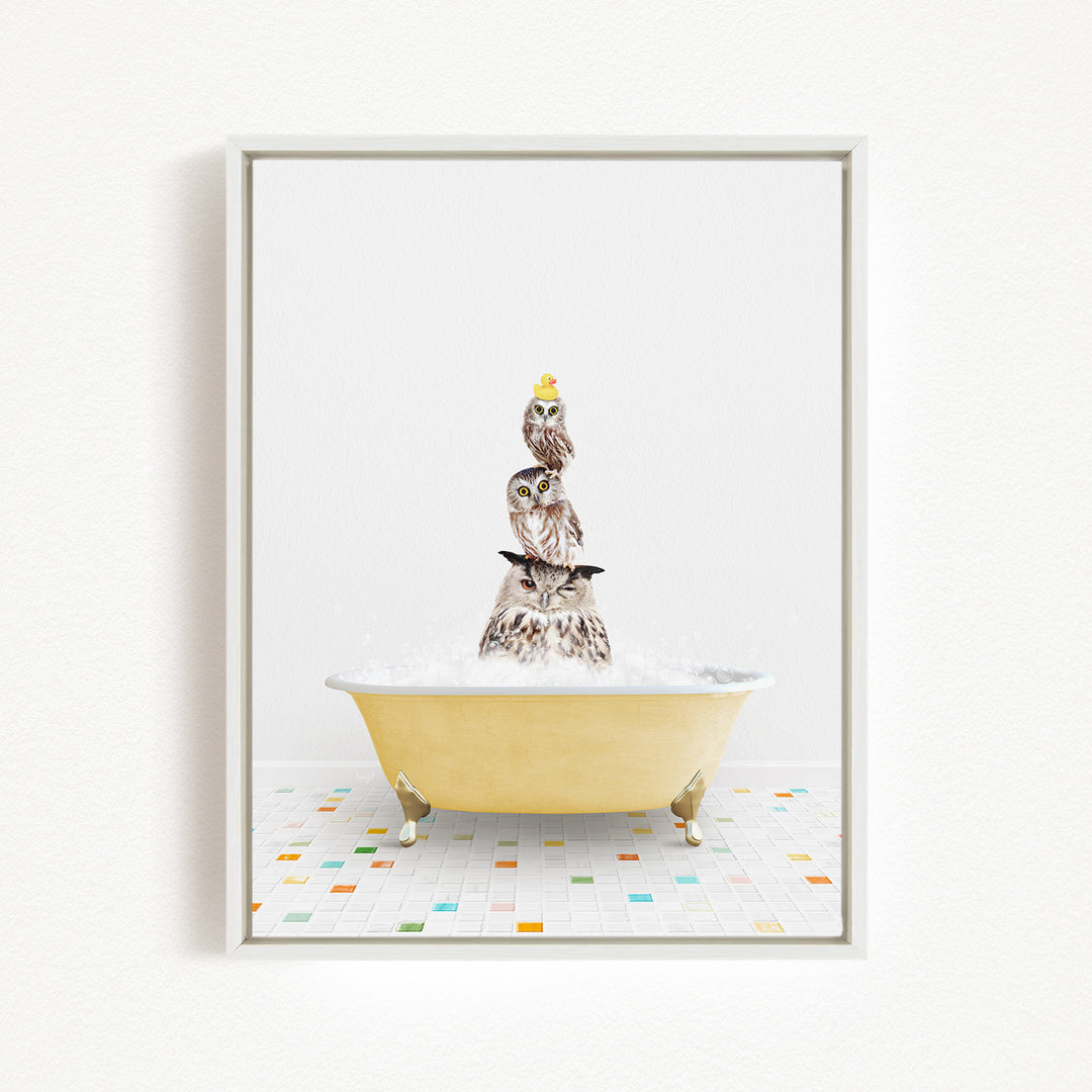 A framed image depicting a group of owls sitting in a yellow bathtub filled with bubbles.