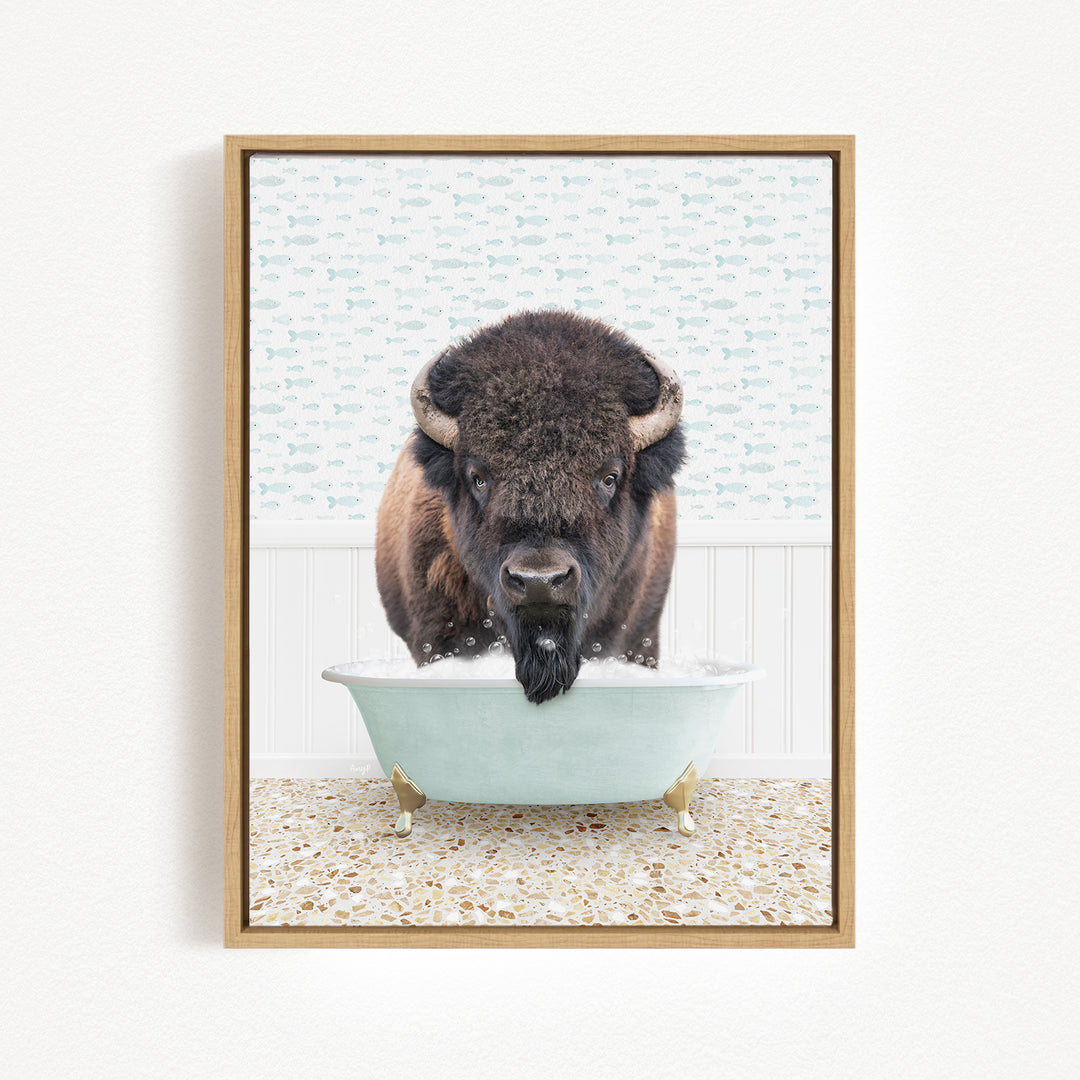 A buffalo with a black mane and horns is standing in a white bathtub filled with water, looking directly at the camera.
