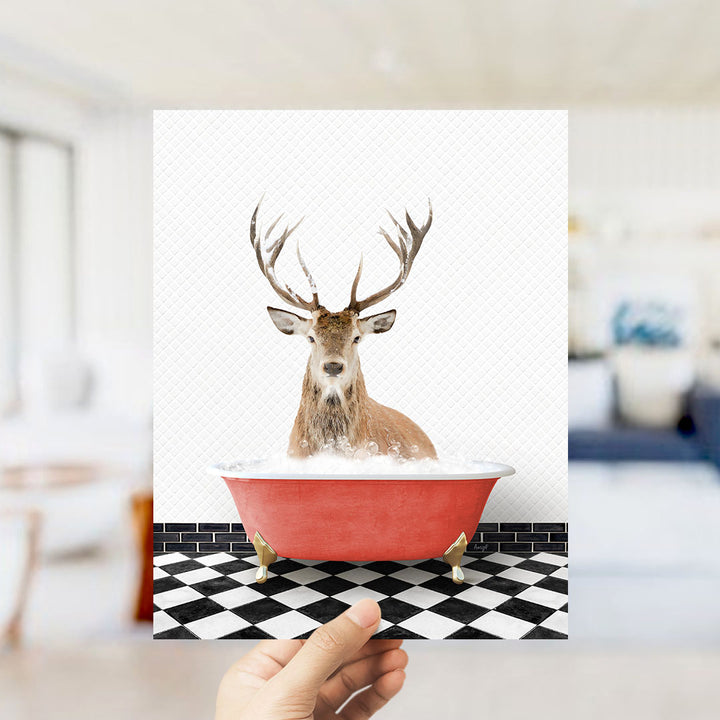 A deer with antlers is sitting in a red bathtub on a black and white checkered floor.