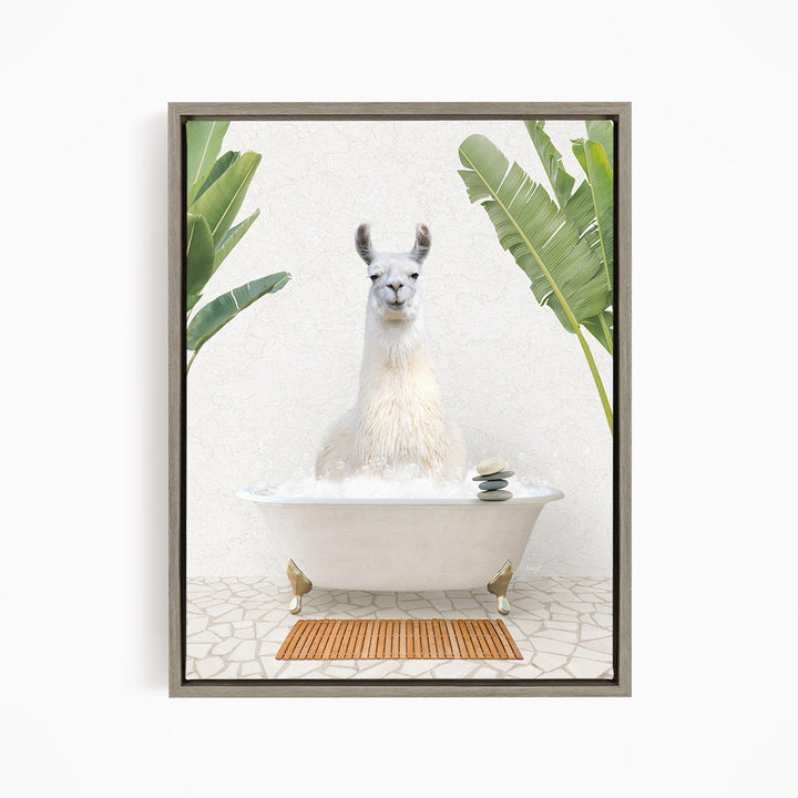 A white llama sitting in a white bathtub filled with bubbles, surrounded by green leaves and a wooden mat on the floor.