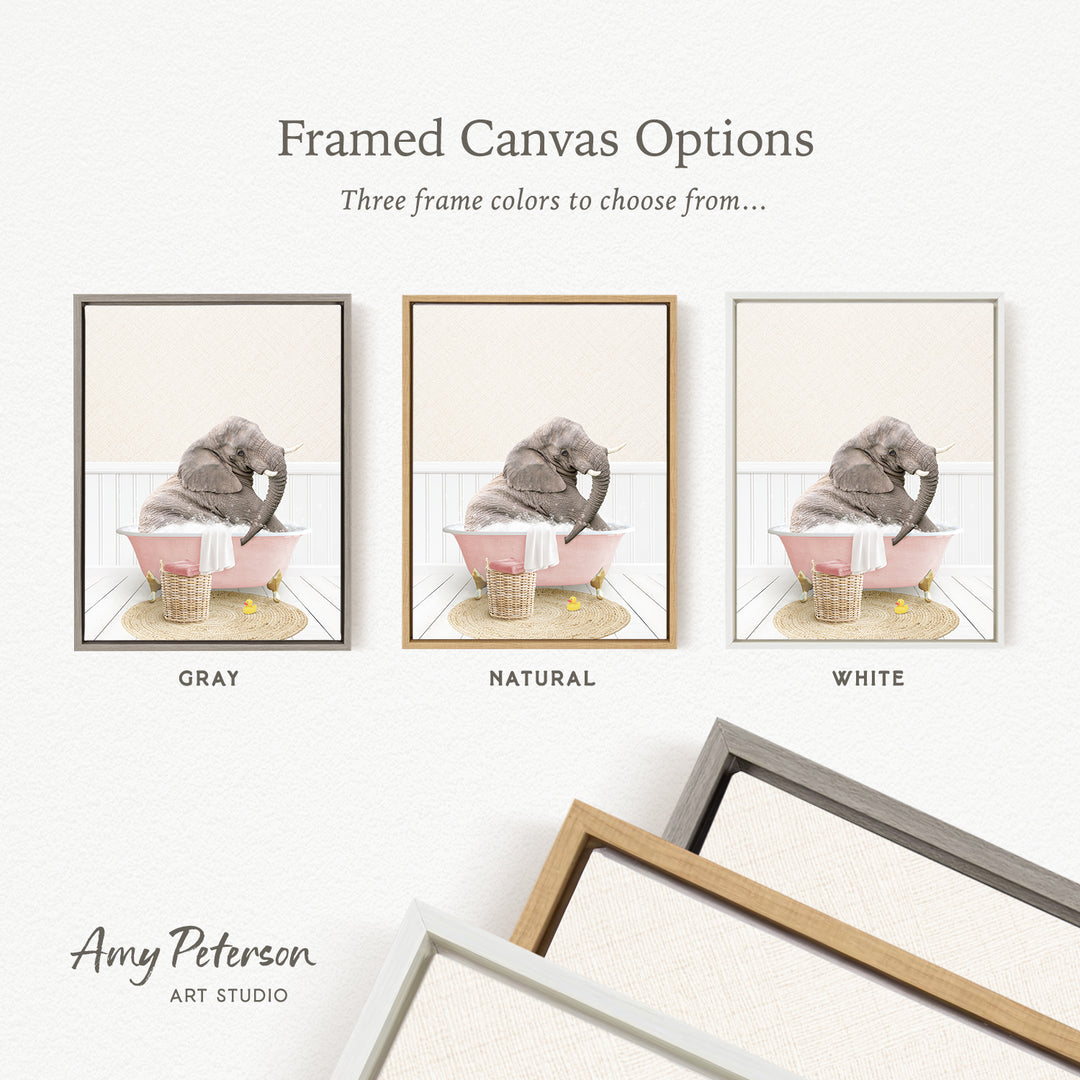 The image is a framed canvas option showcasing three different frame colors: gray, natural, and white. The canvas features a gray elephant sitting in a pink bathtub, with a basket nearby.