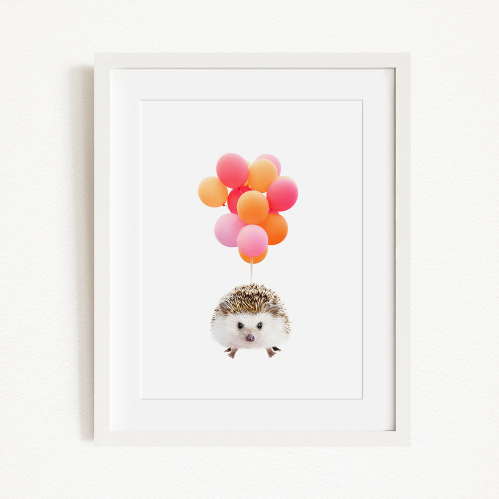 A framed image depicting a hedgehog floating in the air, surrounded by a cluster of colorful balloons.
