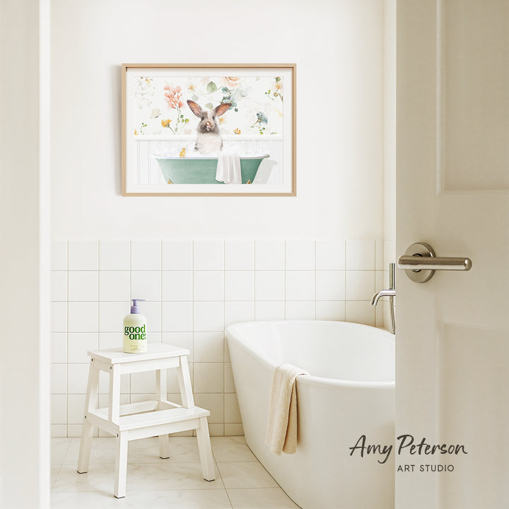 A bathroom interior with a white bathtub, a stool, and a framed picture of a rabbit sitting in a bathtub.