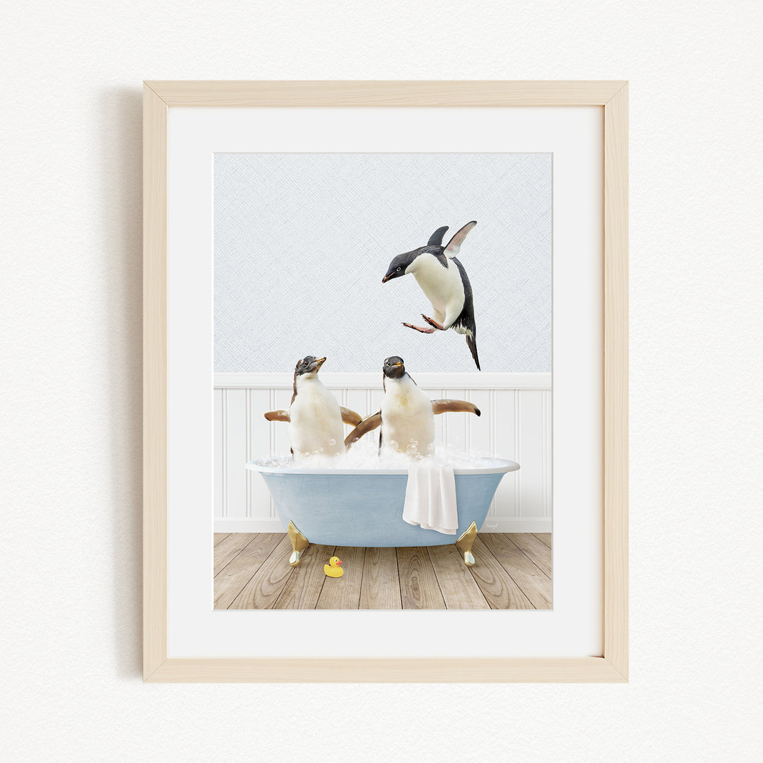 A framed image depicting two penguins sitting in a bathtub, with one penguin flying towards the other.