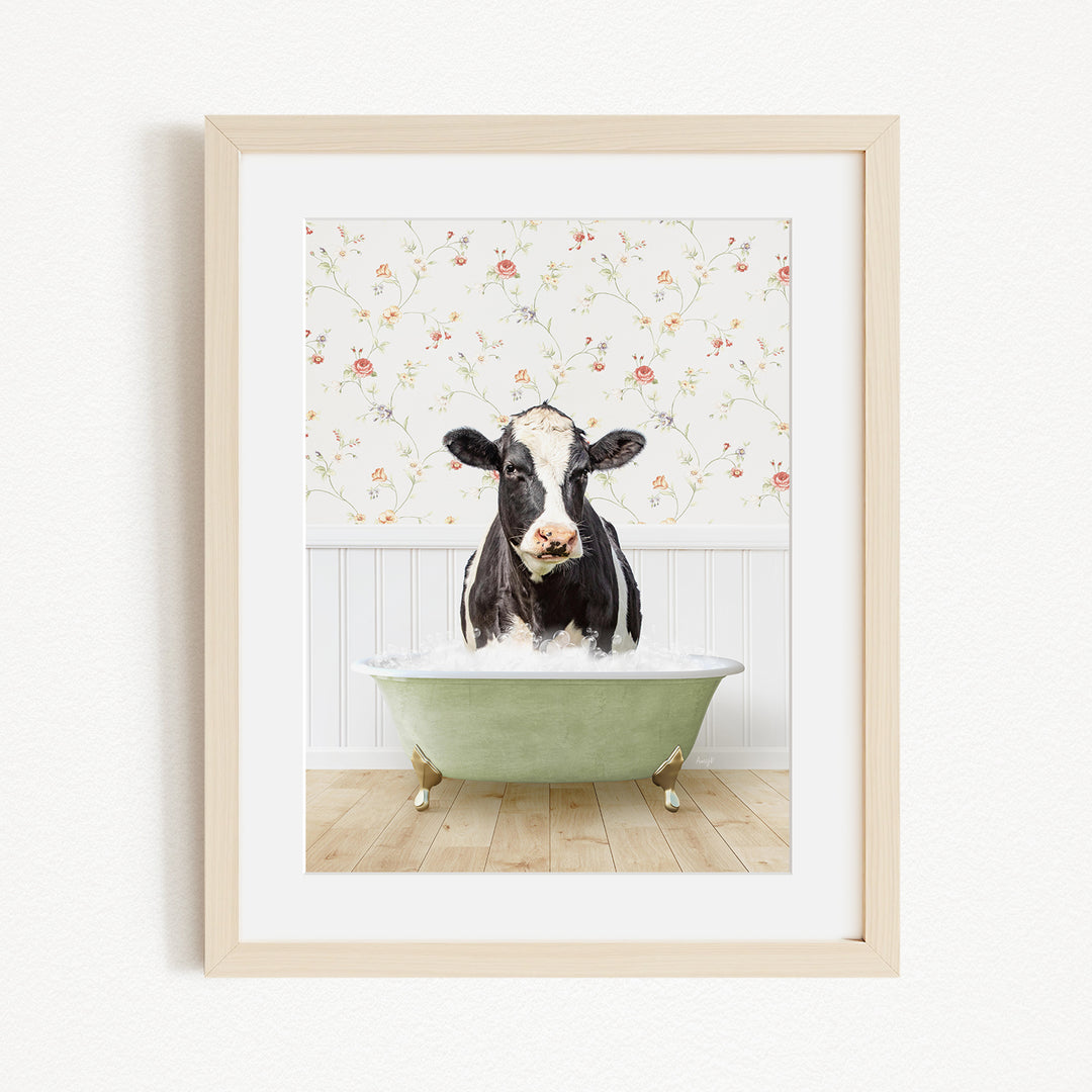 A black and white cow is sitting in a green bathtub filled with water, creating a whimsical and humorous scene.