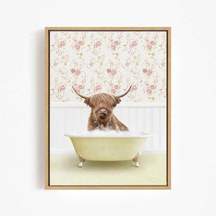 A brown cow with long horns is sitting in a white bathtub filled with bubbles, against a floral wallpaper background.