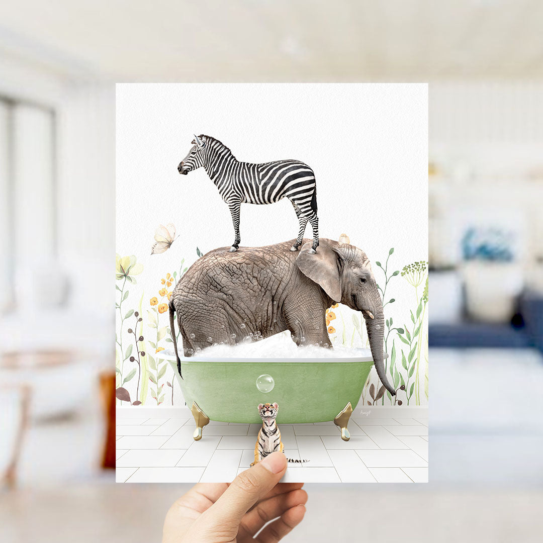 A hand holds up a collage of two images: a zebra standing on an elephant's back in a bathtub, and a small tiger standing in the tub next to the elephant.