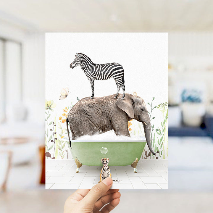 A hand holds up a collage of two images: a zebra standing on an elephant's back in a bathtub, and a small tiger standing in the tub next to the elephant.