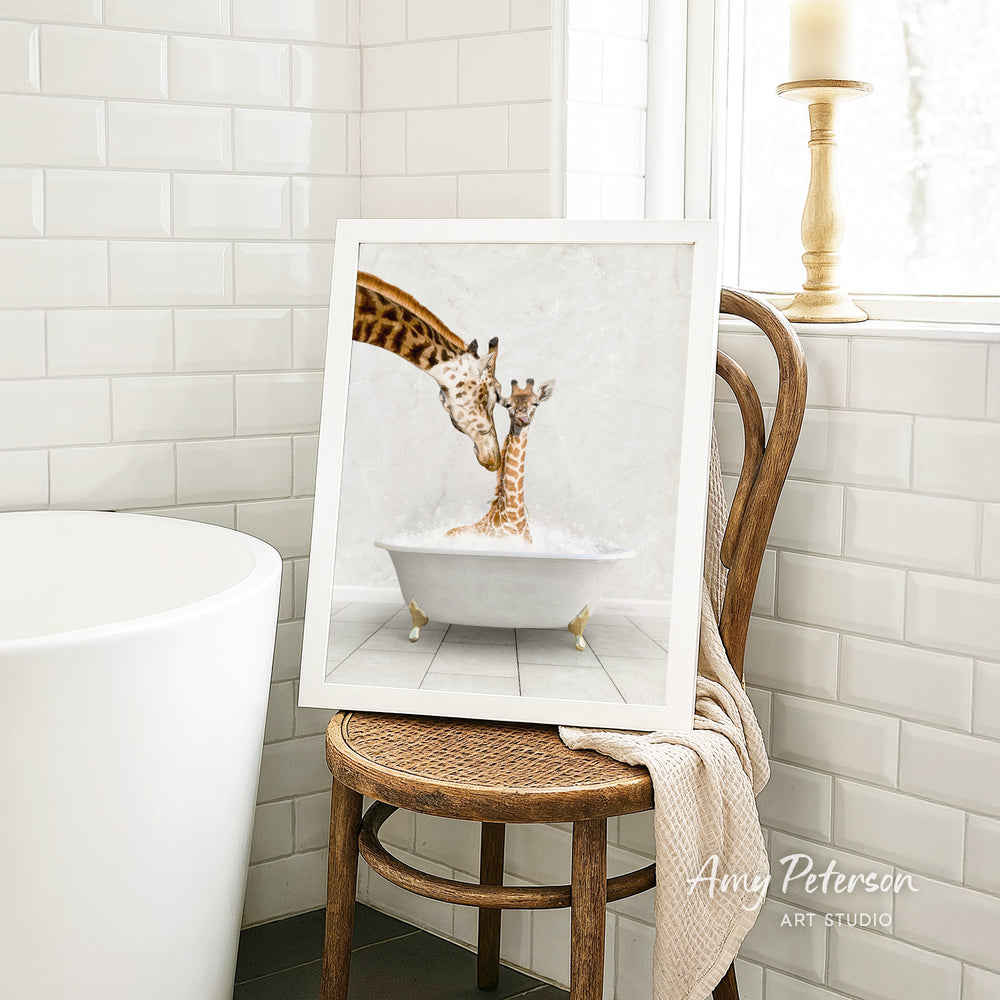 A framed image of two giraffes sitting in a bathtub, with one giraffe appearing to be bathing the other.