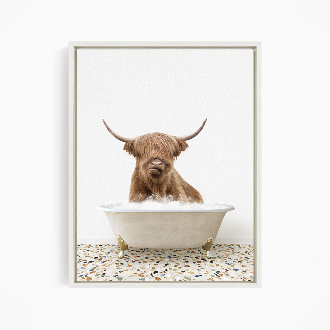 A brown cow with long horns is sitting in a white bathtub filled with water, creating a whimsical and playful scene.