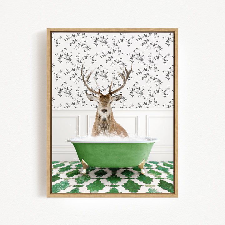 A deer with antlers is sitting in a green bathtub filled with bubbles, surrounded by a patterned tile floor and a white wall with a floral pattern.