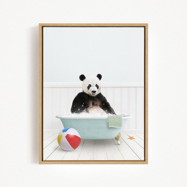 A panda bear sitting in a bathtub filled with water, surrounded by a beach ball and a towel.