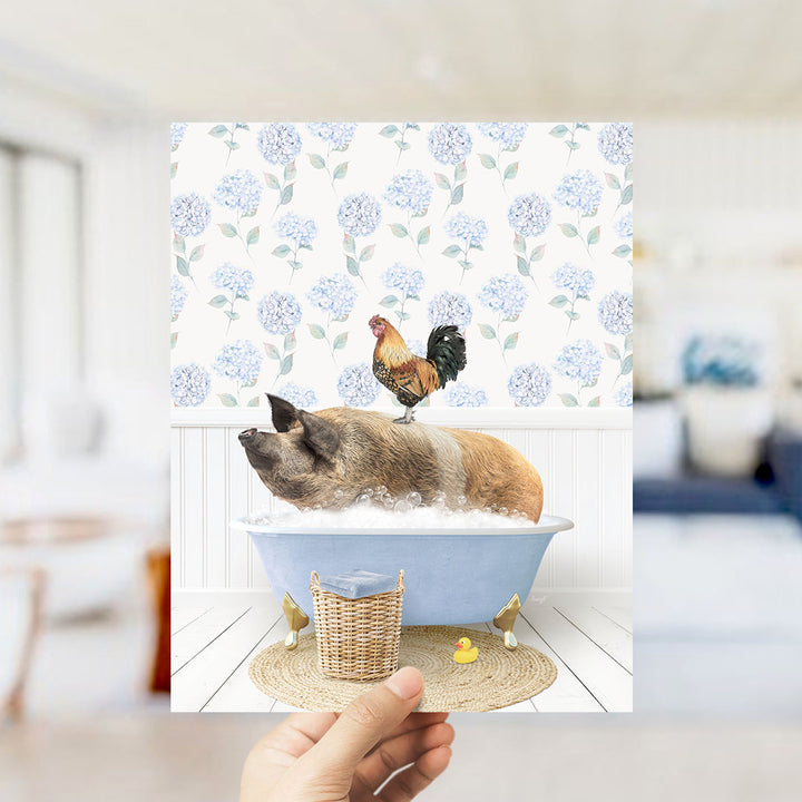 A hand holds up a collage of two images: a pig sitting in a bathtub with a rooster perched on its back, and a yellow rubber duck floating in the water.