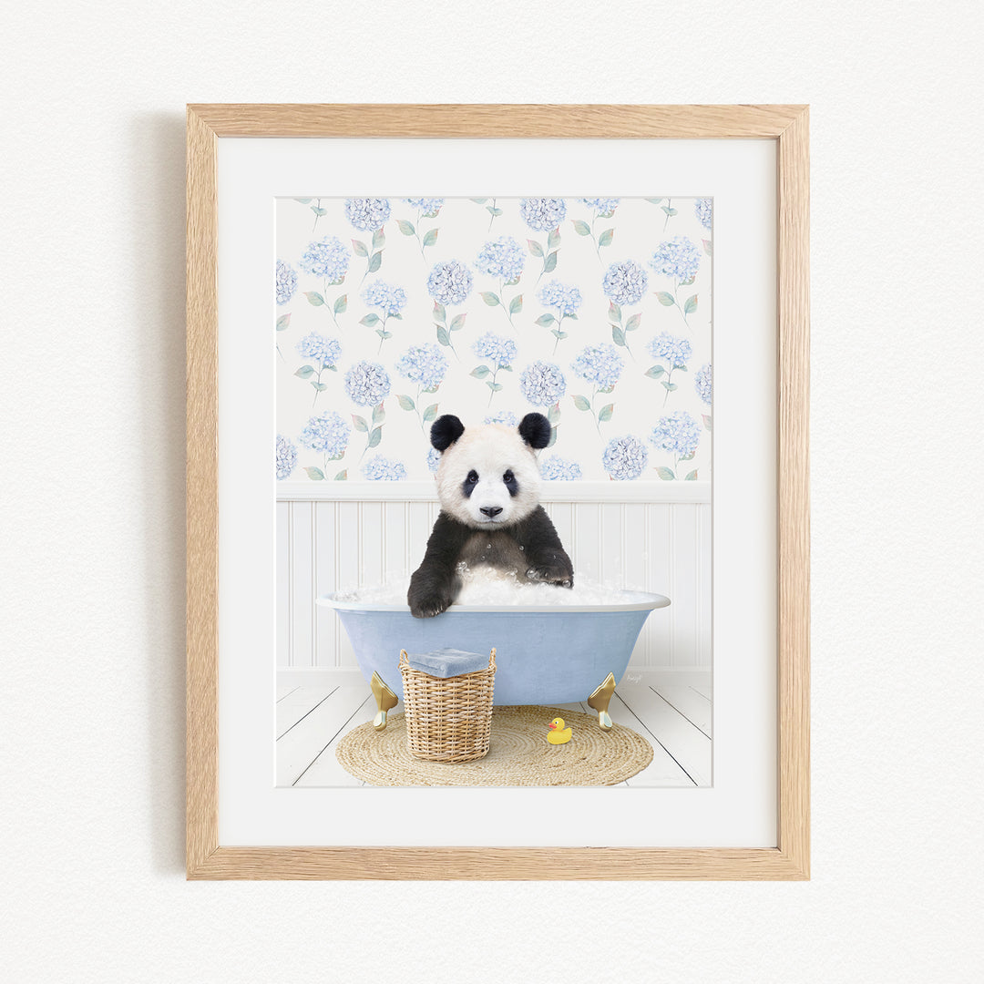 A panda bear sitting in a blue bathtub filled with bubbles, surrounded by a floral patterned wall and a basket of rubber ducks.