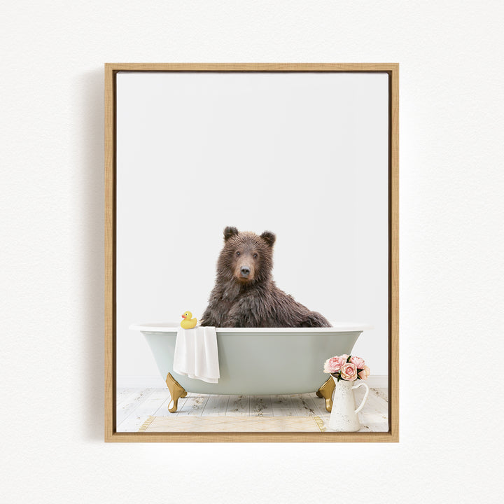 A brown bear sitting in a bathtub, surrounded by a yellow rubber duck and pink flowers.