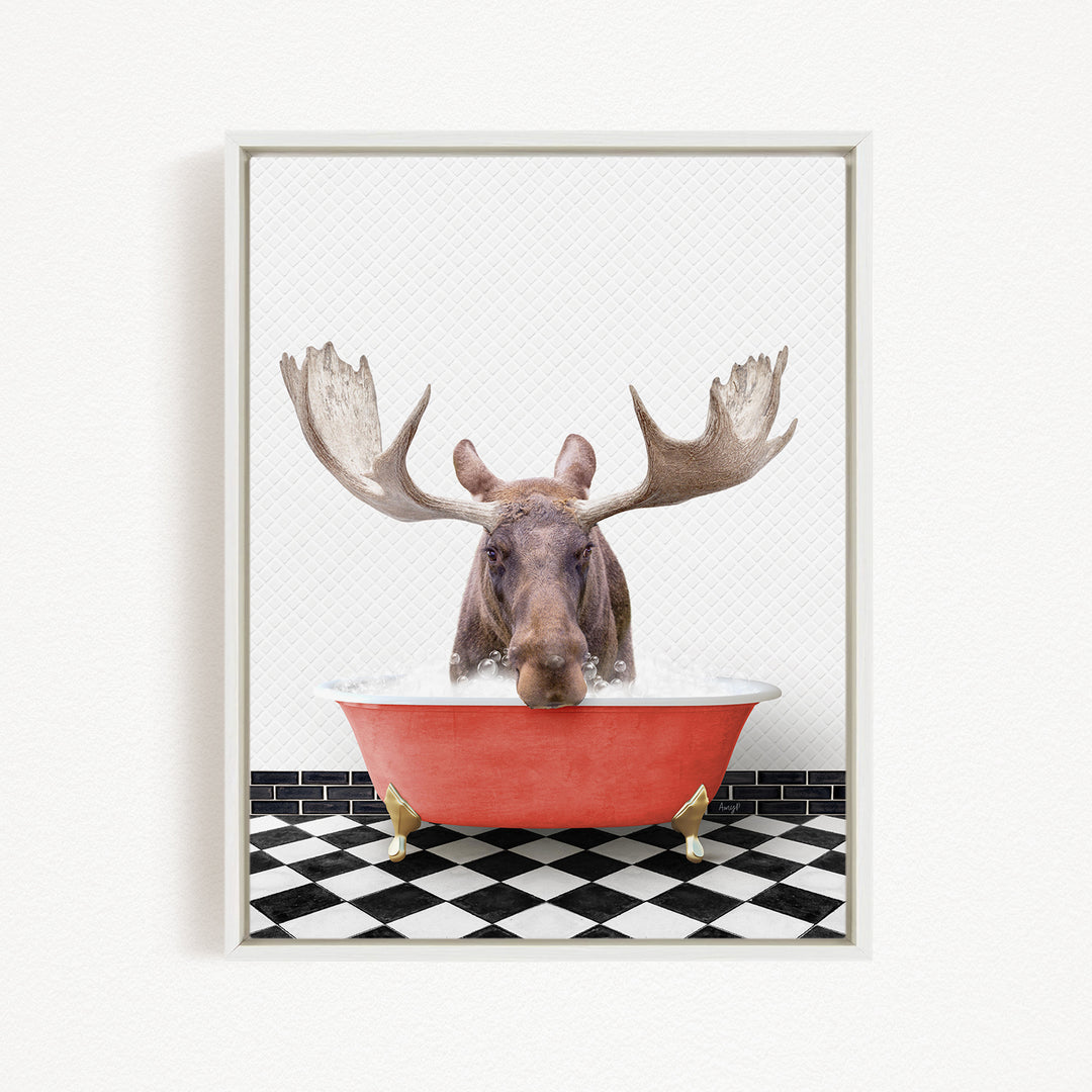 A moose with large antlers is sitting in a red bathtub filled with water, creating a whimsical and humorous scene.