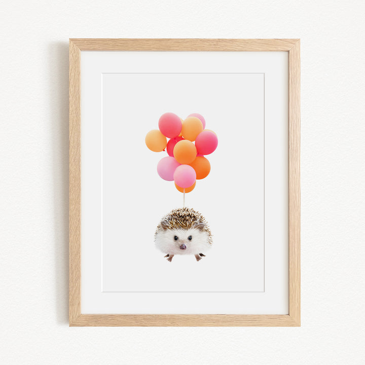 A framed image depicting a hedgehog floating in the air with a bunch of colorful balloons attached to it.