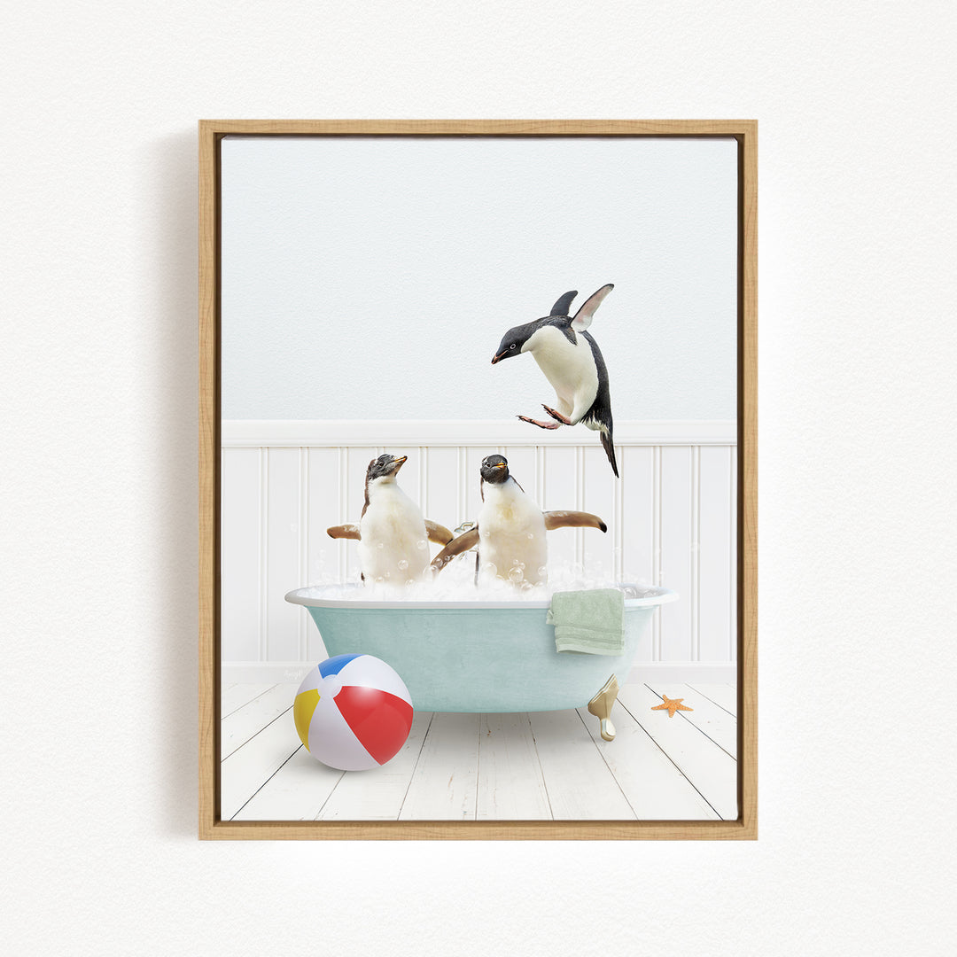 A framed image depicting two penguins standing in a bathtub filled with water, with one penguin jumping out of the tub and another penguin sitting in the tub.