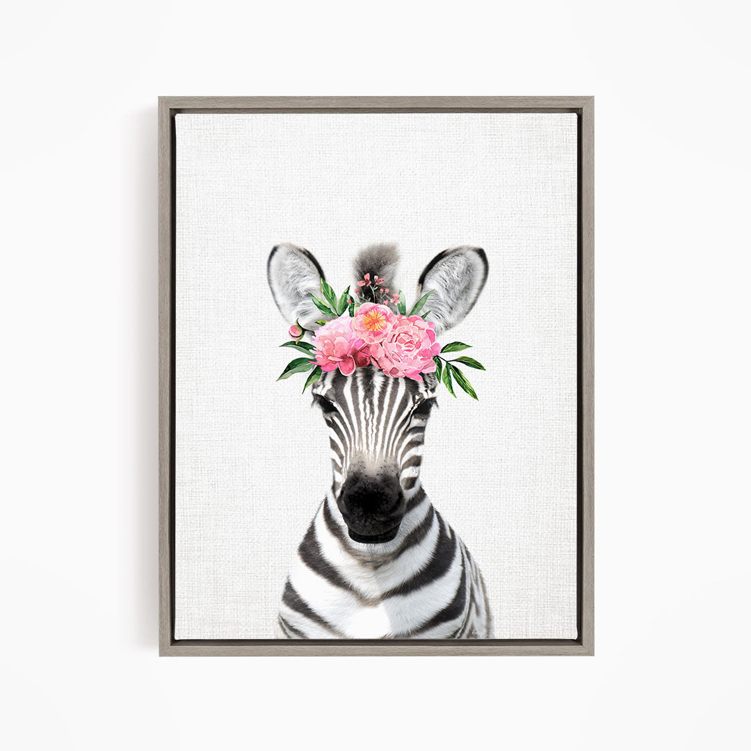 A zebra wearing a floral headpiece with pink flowers and green leaves.