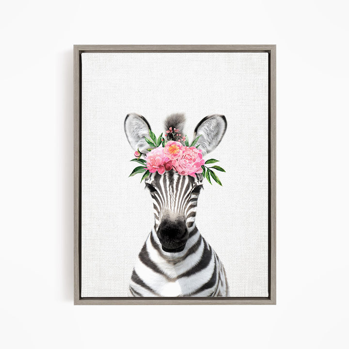 A zebra wearing a floral headpiece with pink flowers and green leaves.