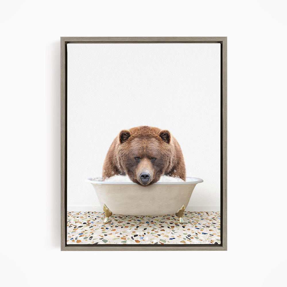 A brown bear is sitting in a white bathtub filled with water, appearing to be enjoying a relaxing bath.