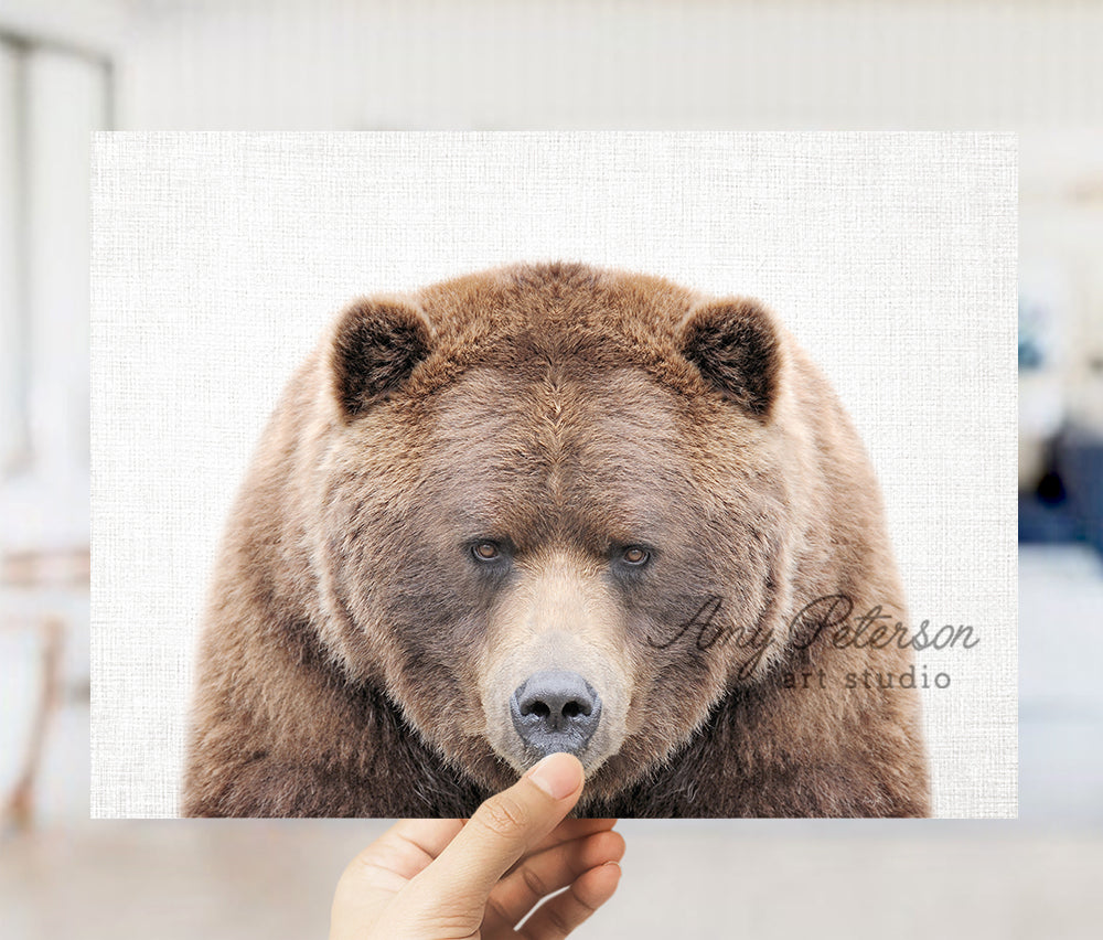 a person holding up a picture of a brown bear