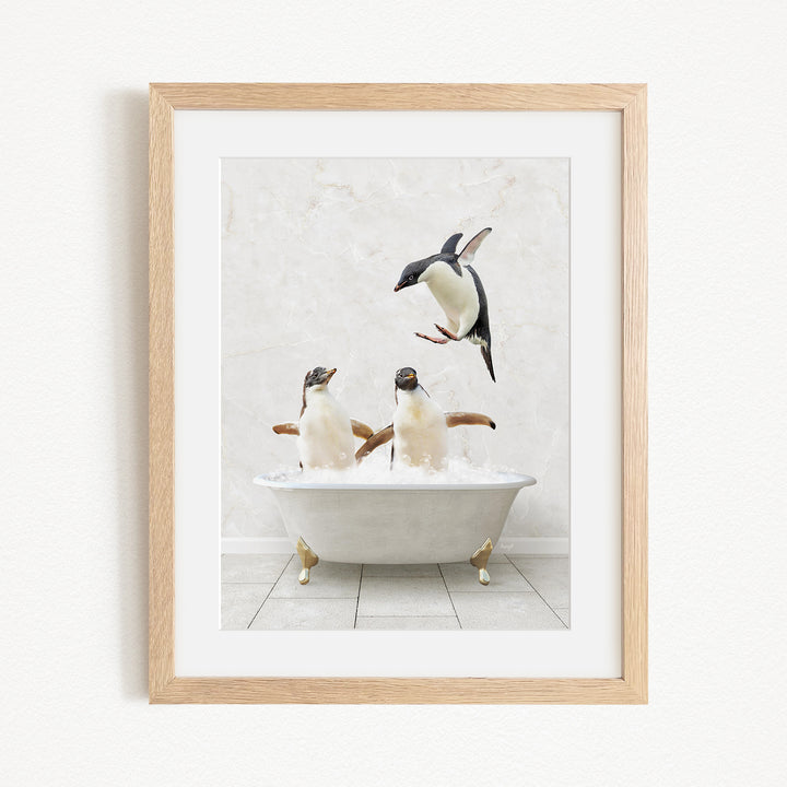 A framed image depicting two penguins sitting in a bathtub, with one penguin flying towards the other penguin.