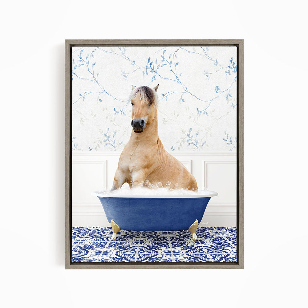 A light brown horse is sitting in a blue bathtub filled with water, surrounded by a blue and white patterned rug.
