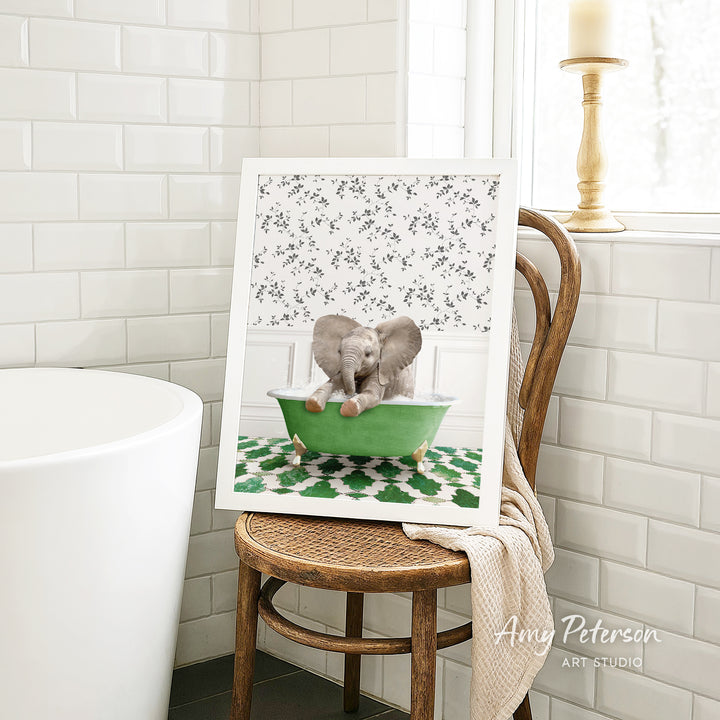 A framed image of two elephants sitting in a green bathtub, with a floral pattern on the wall behind them.