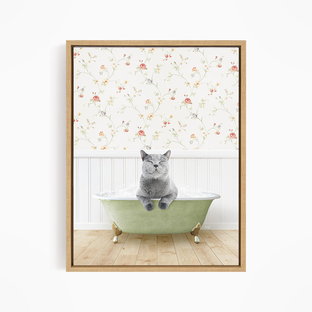 A gray cat sitting in a green bathtub, with a floral wallpaper in the background.