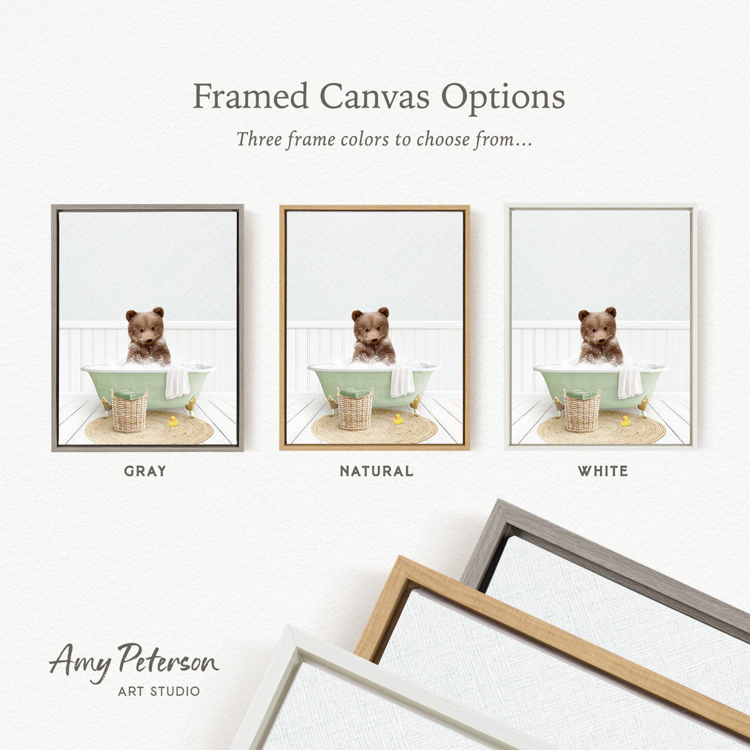 The image is a framed canvas option showcasing three different frame colors: gray, natural, and white. The canvas features a small brown bear sitting in a green bathtub, with a basket nearby.