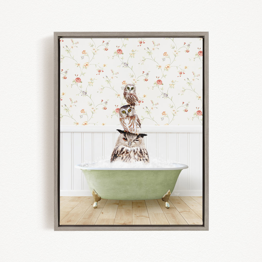 A framed image depicting three owls sitting in a green bathtub, with a floral wallpaper in the background.