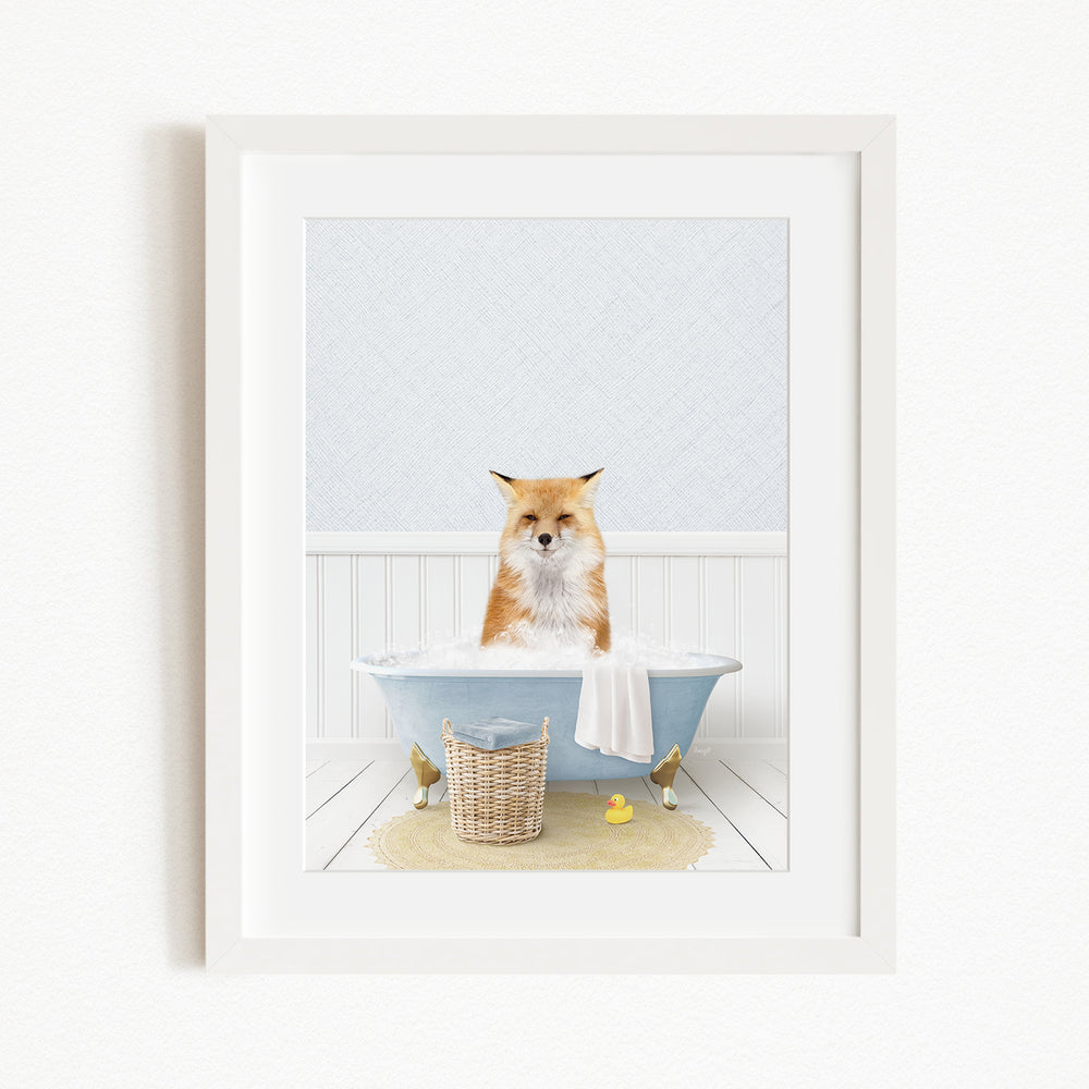 A red fox is sitting in a blue bathtub filled with bubbles, surrounded by rubber ducks and a basket.