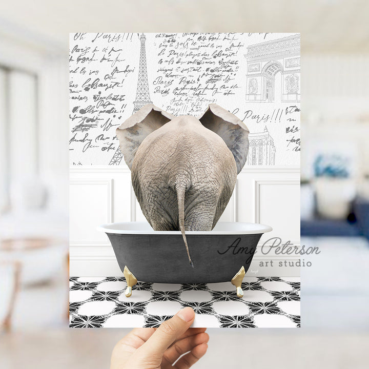 a person holding up a card with an elephant in a bathtub