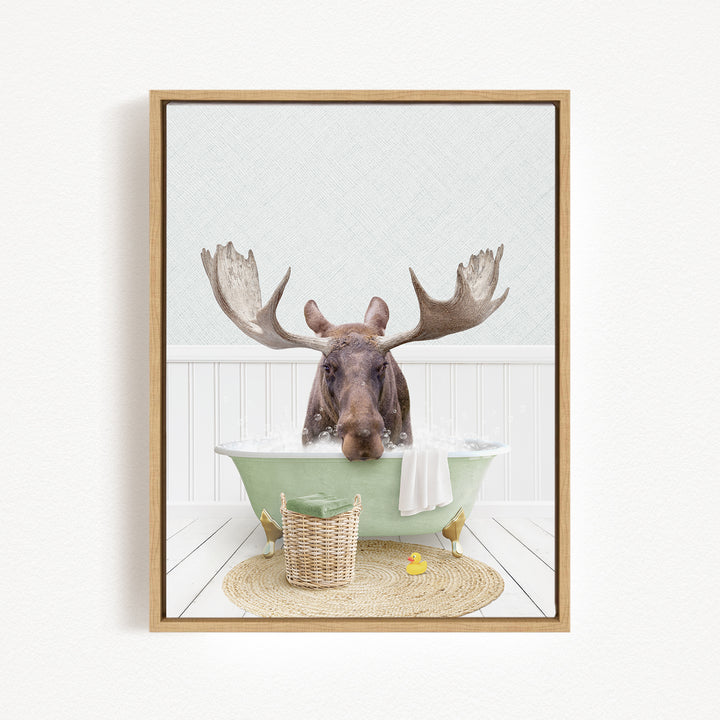 A moose is sitting in a green bathtub filled with water, surrounded by a basket and a rubber duck.