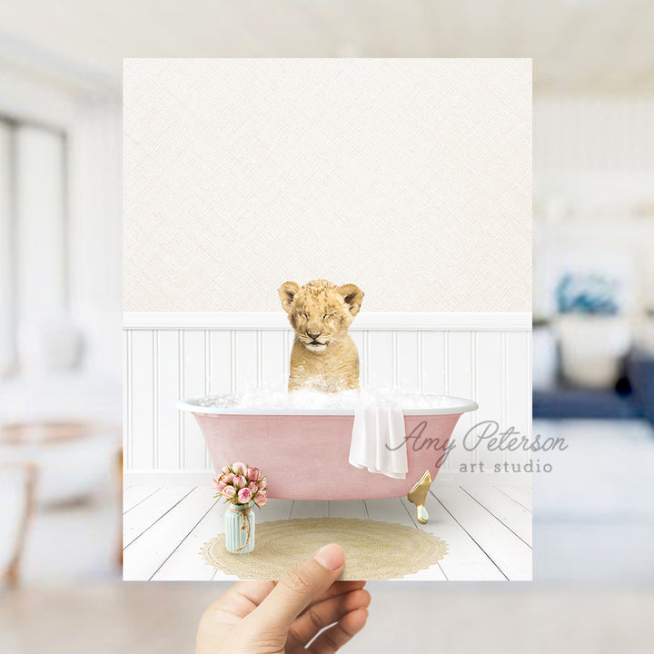 a hand holding a card with a picture of a baby lion in a bathtub