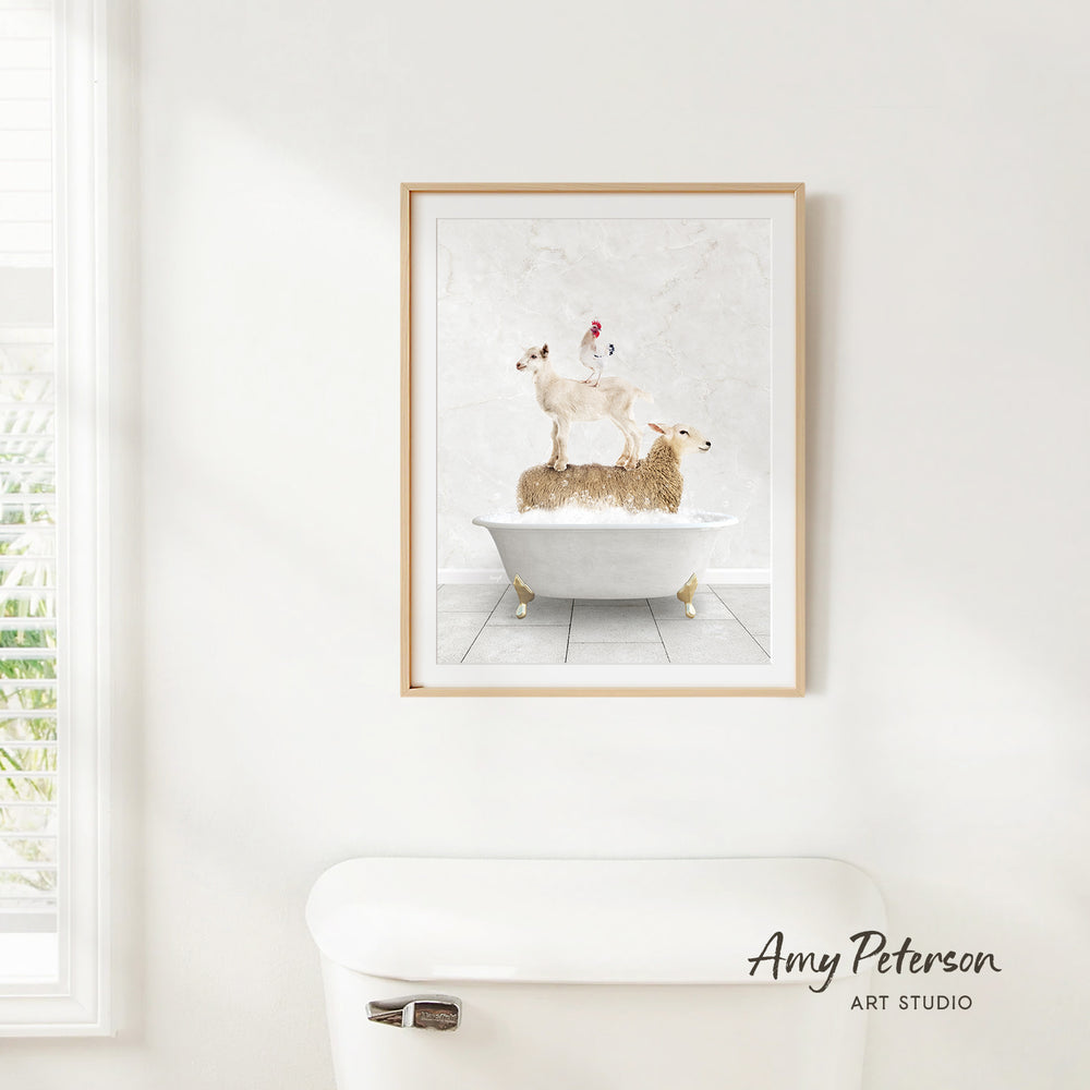 A framed print of a sheep standing on a bathtub is hanging on a white wall in a bathroom.