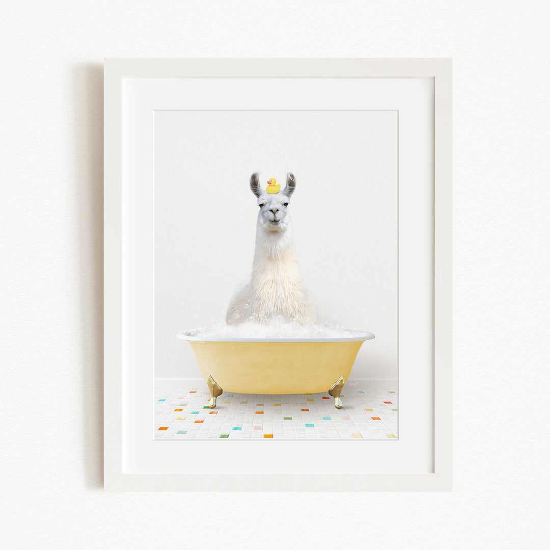 A white llama sitting in a yellow bathtub filled with bubbles, with a rubber duck floating on the water.