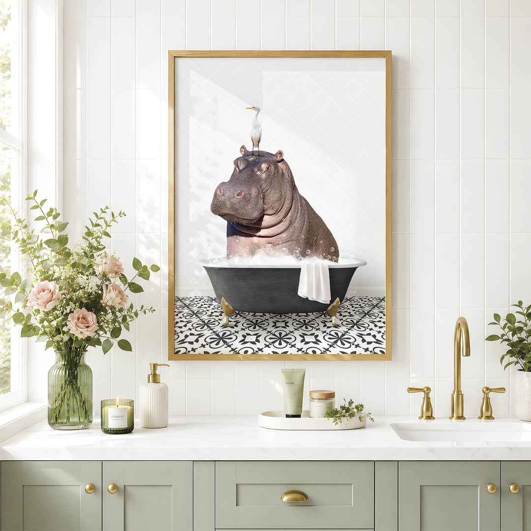 A framed image of a hippopotamus sitting in a bathtub, surrounded by flowers and a decorative vase, is displayed on a wall above a bathroom sink.