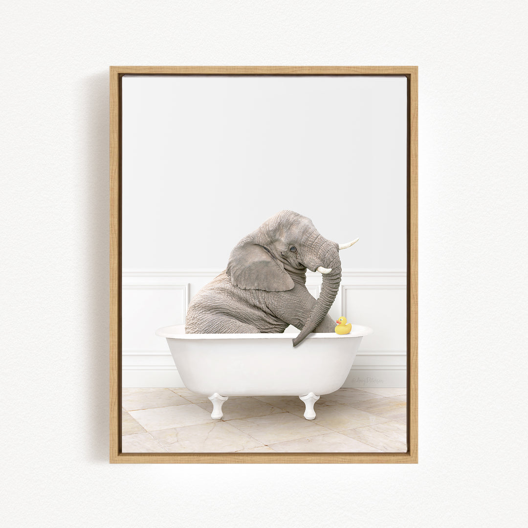 A gray elephant is sitting in a white bathtub, holding a yellow rubber duck.