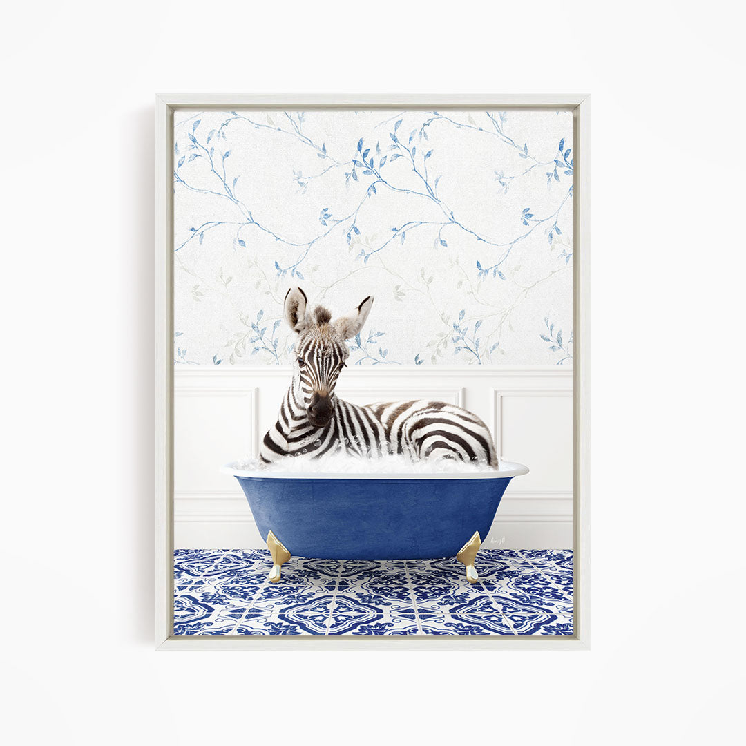 A zebra is sitting in a blue bathtub, surrounded by a patterned tile floor and a floral wallpaper background.